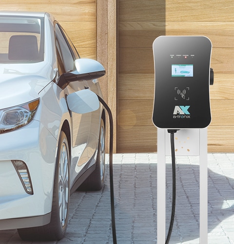 Білий електромобіль заряджається від чорної настінної зарядки від a-TroniX.